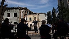 Le chef d'orchestre German Makarenko dirige l'orchestre qui joue sur le site de l'attaque de missiles russes sur l'hôpital pour enfants, à Kiev, en Ukraine, le 12 juillet 2024.
