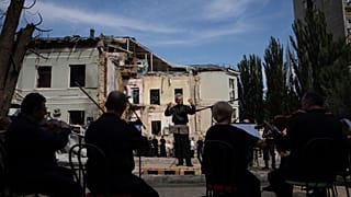The conductor German Makarenko leads the orchestra, which is playing on the site of the Russian missile attack on the children's hospital, in Kyiv, Ukraine, July 12, 2024