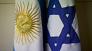 علم أرجنتيني إلى جانب علم إسرائيلي في مكتب غييرمو بورغر، رئيس مركز الجالية اليهودية AMIA، في بوينس آيرس، الأرجنتين، في 8 فبراير 2013.