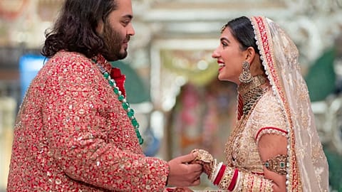 Anant Ambani, left, holds hands with Radhika Merchant during their wedding ceremony in Mumbai, July 12, 2024