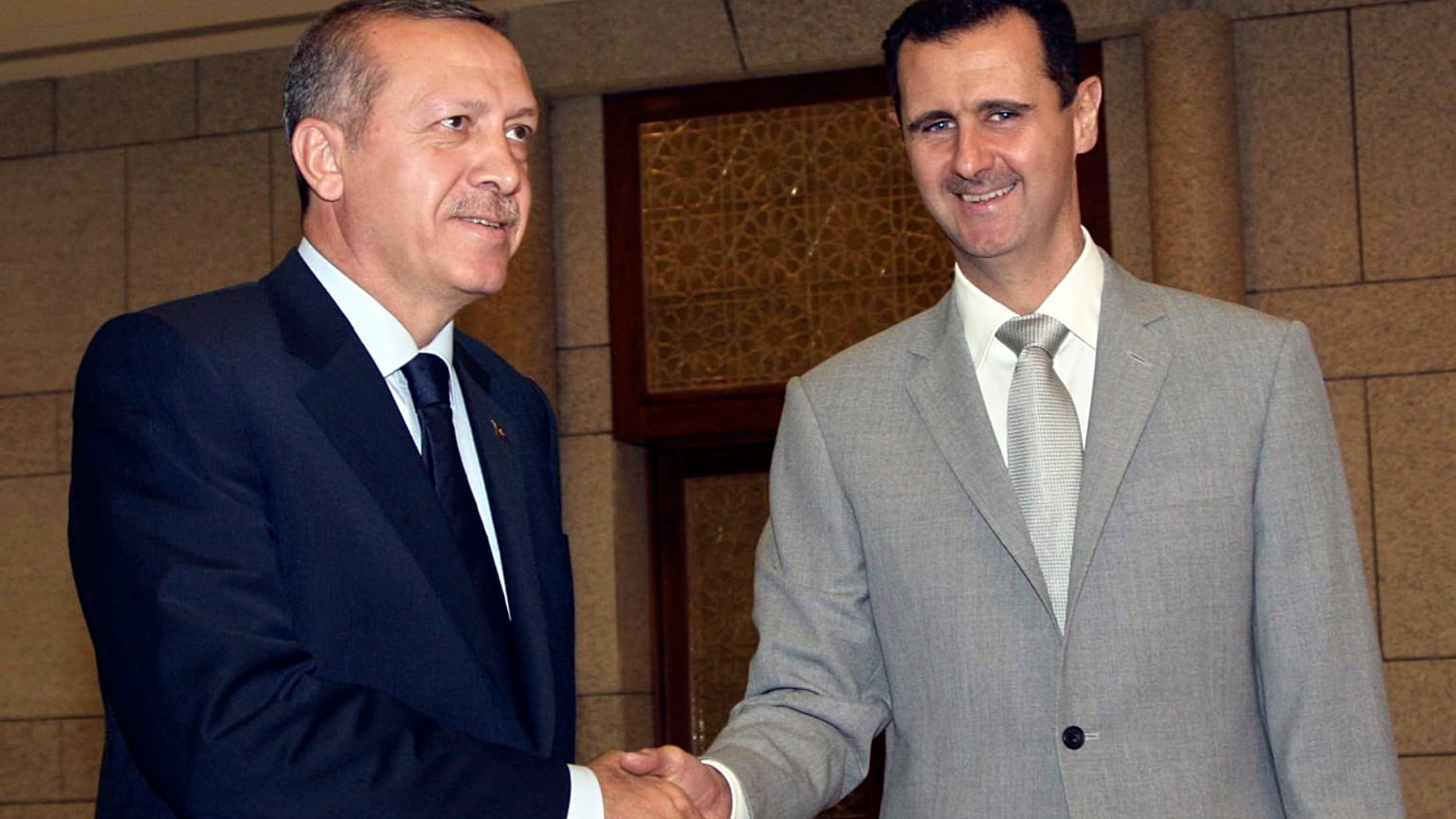 الرئيس السوري بشار الأسد، إلى اليمين، يصافح رئيس الوزراء التركي رجب طيب أردوغان في قصر الشعب الرئاسي في دمشق، سوريا، في 11 أكتوبر 2010. 