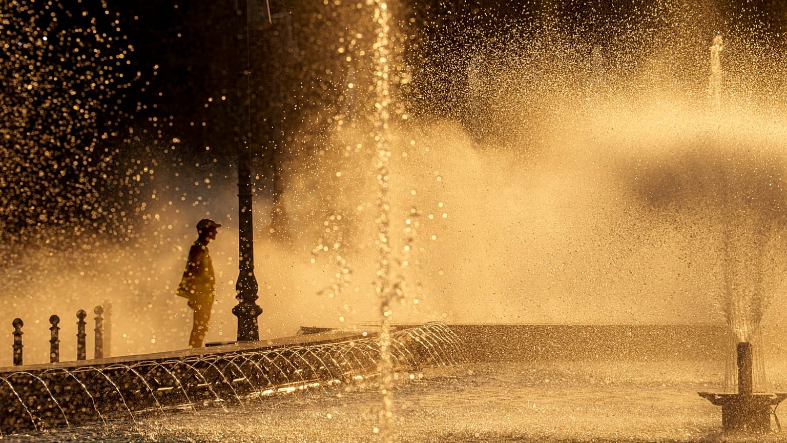 Un employé municipal se rafraîchit près d'une fontaine à Bucarest, en Roumanie, le jeudi 11 juillet 2024, alors que les températures ont dépassé 39 °C.