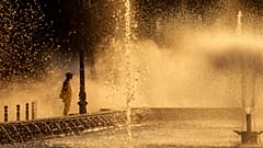 Un employé municipal se rafraîchit près d'une fontaine à Bucarest, en Roumanie, le jeudi 11 juillet 2024, alors que les températures ont dépassé 39 °C.