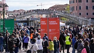 Stewards check tourists' QR code access outside the main train station in Venice, Italy, Thursday, April 25, 2024.