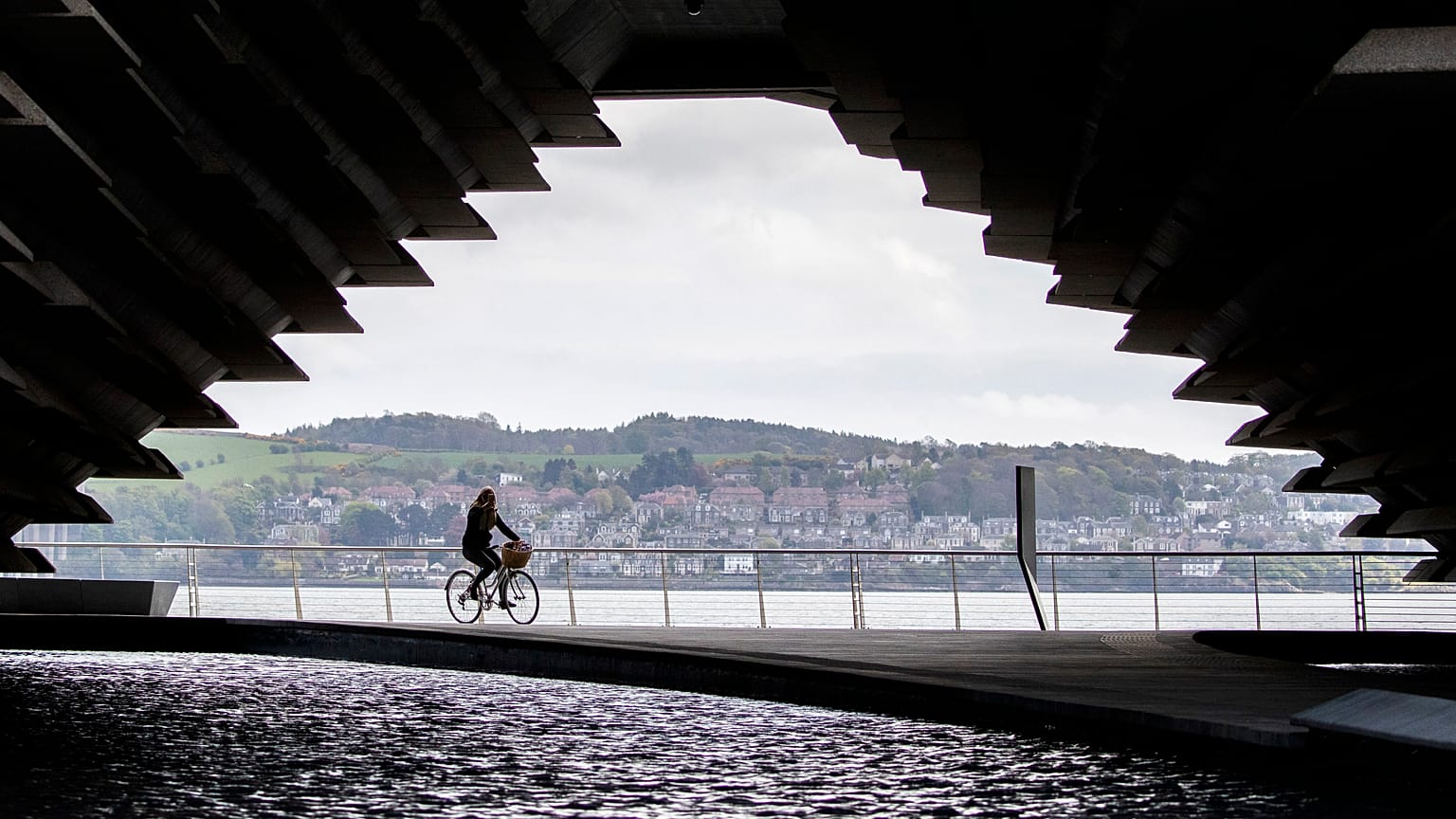 A cyclist rides along the River Tay in Dundee, Scotland.