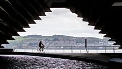 A cyclist rides along the River Tay in Dundee, Scotland.