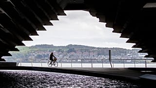 A cyclist rides along the River Tay in Dundee, Scotland.