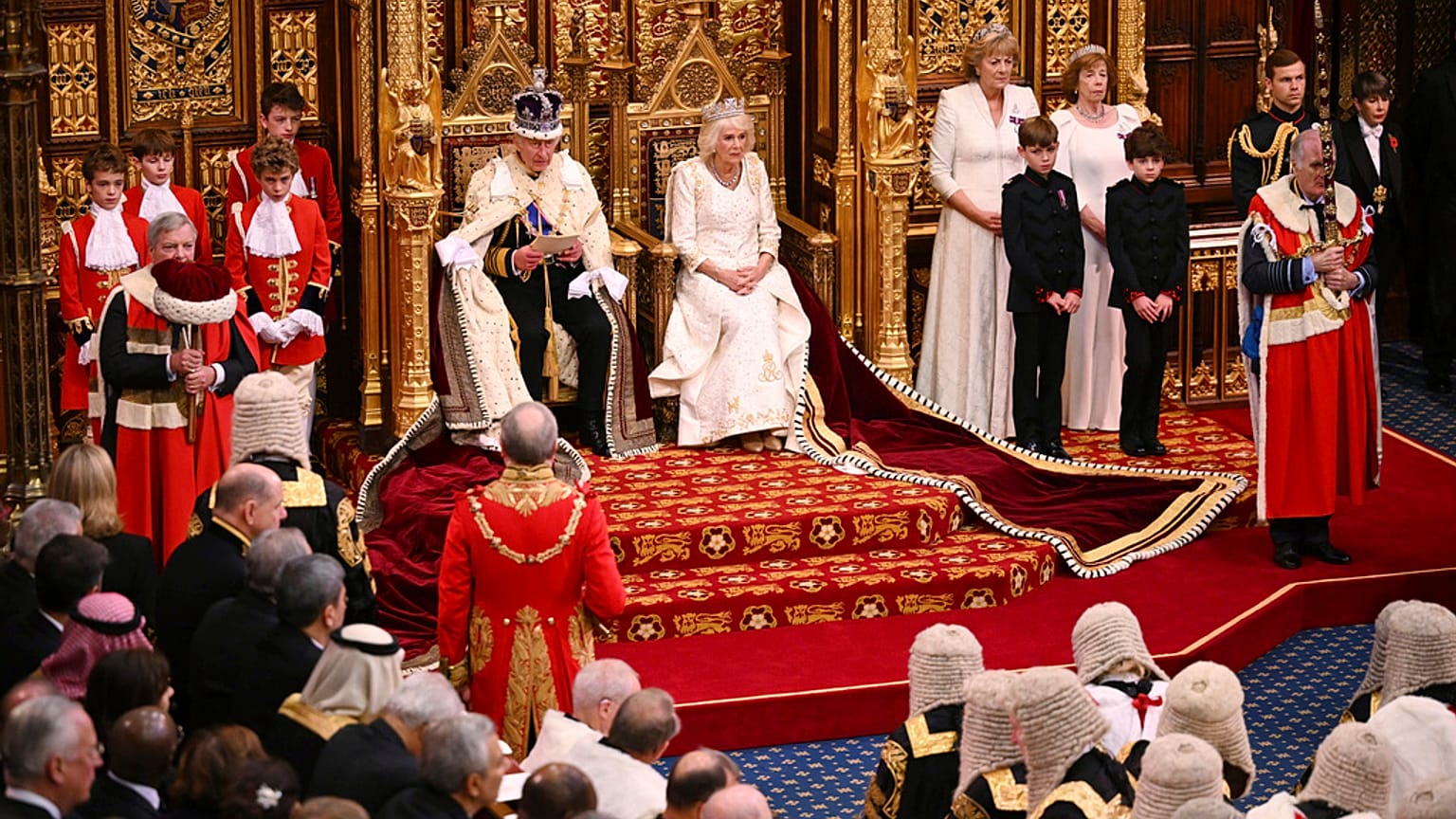 O rei Carlos III da Grã-Bretanha senta-se ao lado da rainha Camila durante a abertura do Parlamento no Palácio de Westminster em Londres, terça-feira, 7 de novembro de 2023.