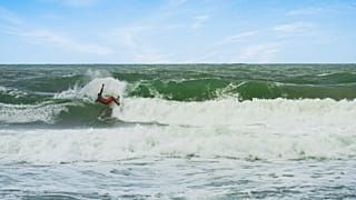 Un hombre surfea en aguas brasileñas