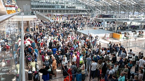 Travelers wait in Terminal 1 for check-in at Hamburg Airport after IT outage causes travel chaos, July 19, 2024