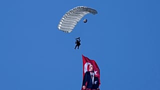 Ein türkischer Fallschirmspringer schwebt mit einer türkischen Flagge und einem Porträt von Atatürk über die Militärparade im türkisch besetzten Teil Nikosias, 20. Juli 2024.