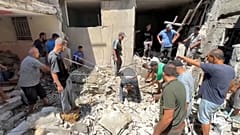 Palestinians look at the aftermath of the Israeli bombing in Nuseirat refugee camp, Gaza Strip.