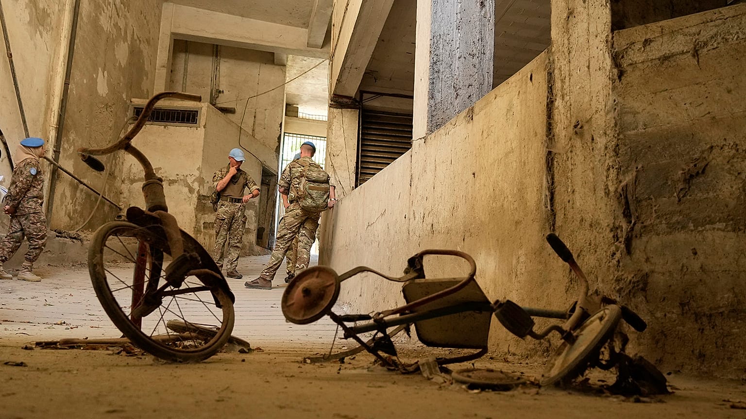 Peacekeepers stand behind two kids’ bicycles inside of an abandoned building inside the UN controlled buffer zone in the central of the divided capital Nicosia, 6 June 2024