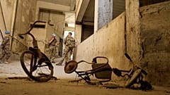 Peacekeepers stand behind two kids’ bicycles inside of an abandoned building inside the UN controlled buffer zone in the central of the divided capital Nicosia, 6 June 2024