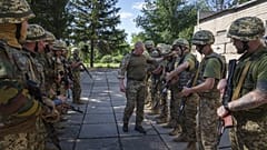 Ukrán katonai oktató ellenőrzi besorozott foglyok fegyvereit