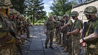 Ukrán katonai oktató ellenőrzi besorozott foglyok fegyvereit