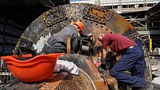 Workers repair damaged thermal power plant, one of the country's largest, recently destroyed by Russian missiles near Kharkiv, 12 April 2024