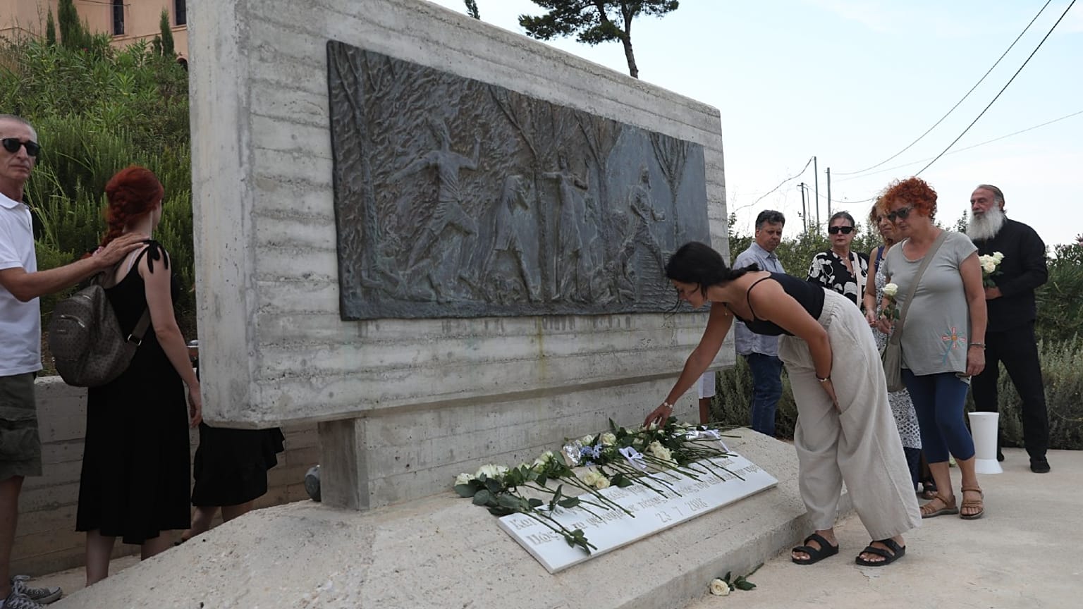 Συγγενείς και φίλοι των θυμάτων και πληγέντες από την καταστροφική πυρκαγιά στο Μάτι και τη Ραφήνα αφήνουν λουλούδια στο Μνημείο των θυμάτων της πυρκαγιάς