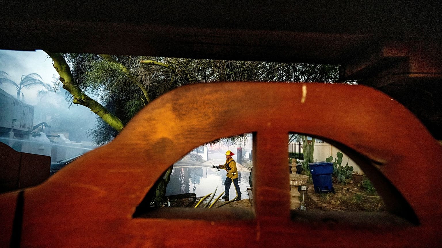 Un pompier arrose le garage d'une maison détruite par l'incendie de Hawarden à Riverside, Californie, le 21 juillet 2024.