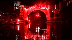 Ένας δύτης που κρατά πυρσούς πηδάει από την Παλιά Γέφυρα κατά τη διάρκεια νυχτερινής επίδειξης, μέρος του 456ου παραδοσιακού ετήσιου διαγωνισμού καταδύσεων στο Μόσταρ της Βοσνίας, Κυριακή 31 Ιουλίου 2024. 