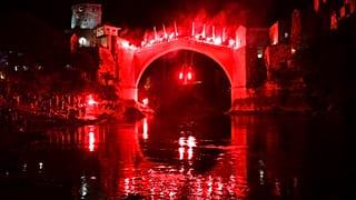 Ένας δύτης που κρατά πυρσούς πηδάει από την Παλιά Γέφυρα κατά τη διάρκεια νυχτερινής επίδειξης, μέρος του 456ου παραδοσιακού ετήσιου διαγωνισμού καταδύσεων στο Μόσταρ της Βοσνίας, Κυριακή 31 Ιουλίου 2024. 