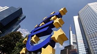 A man walks past a Euro sign in the hallway of the European Central Bank in Frankfurt, Germany