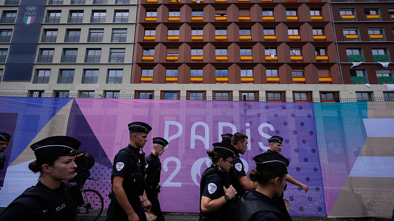 Police walk outside the perimeter of the Olympic Village, past housing for the Spanish, Italian and Moroccan teams, at the 2024 Summer Olympics, July 23, 2024, in Paris