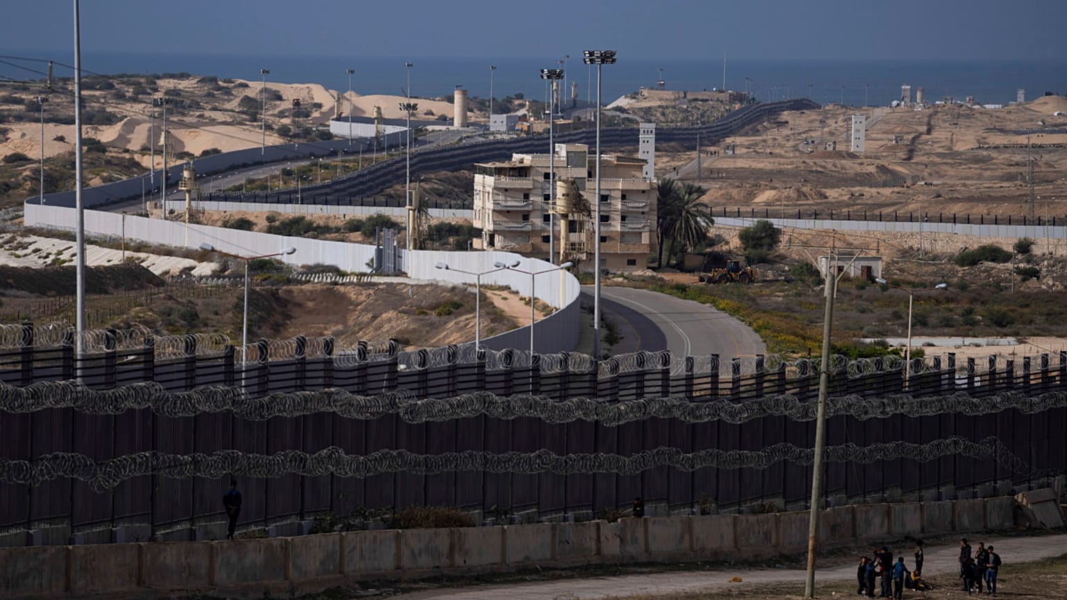 فلسطينيون نزحوا بسبب القصف الإسرائيلي لقطاع غزة يسيرون بجوار الحدود مع مصر، في رفح، جنوب غزة، الأحد، 14 يناير، 2024. 