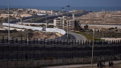 فلسطينيون نزحوا بسبب القصف الإسرائيلي لقطاع غزة يسيرون بجوار الحدود مع مصر، في رفح، جنوب غزة، الأحد، 14 يناير، 2024. 