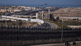 فلسطينيون نزحوا بسبب القصف الإسرائيلي لقطاع غزة يسيرون بجوار الحدود مع مصر، في رفح، جنوب غزة، الأحد، 14 يناير، 2024. 