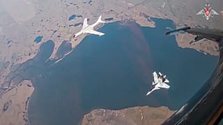 Çin hava kuvvetlerine ait bir H-6K uzun menzilli bombardıman uçağı, solda, Rusya-Çin ortak hava devriyesi sırasında Rus hava kuvvetlerine ait bir Su-30 avcı uçağı tarafından eşlik edilirken görülüyor, 25 Temmuz 2024