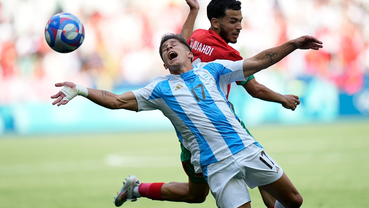اللاعب الأرجنتيني جوليانو سيميوني في المقدمة واللاعب المغربي زكريا الواحدي يتصارعان على الكرة خلال مباراة في أولمبياد باريس 2024