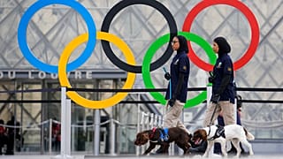  حلقات أولمبية معلقة أمام متحف اللوفر بباريس وسيدتان من الفريق الامني الإماراتي برفقة كلبي حراسة