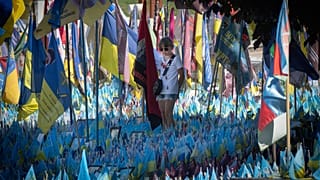 Yakınları tarafından getirilen ve her biri bir askerin adını taşıyan bayraklar, Kiev'de Rus birlikleriyle girdikleri çatışmada ölenlerin anısına yapılan derme çatma bir anıtı süslüyor