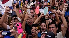Muhalefetin başkan adayı Edmundo Gonzalez'in destekçileri, 25 Temmuz 2024 Perşembe günü Venezuela'nın başkenti Caracas'ta düzenlenen seçim kampanyası kapanış mitinginde tezahürat yapıyor. Başkan