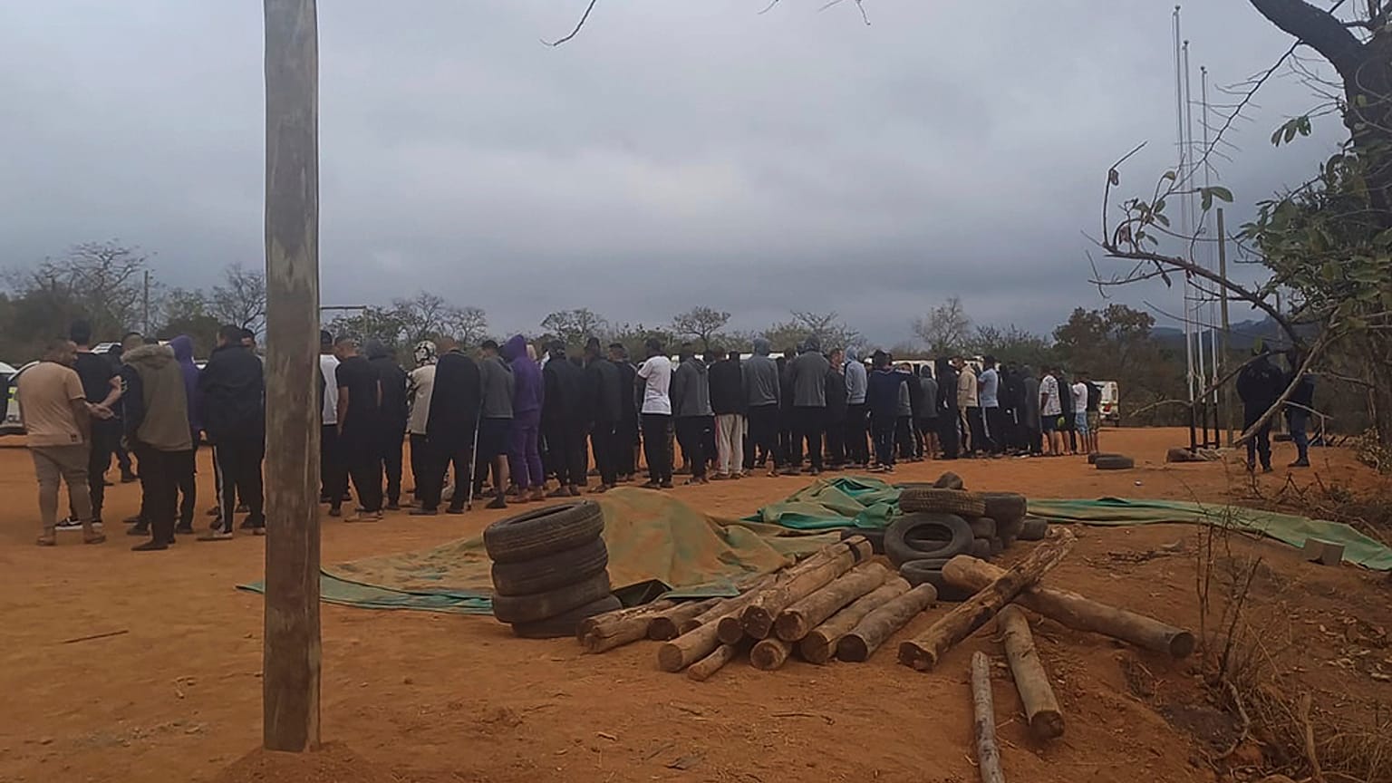 مواطنون ليبيون يصطفون داخل معسكر غير قانوني إثر اعتقالهم، الجمعة، في بلدة النهر الأبيض بجنوب إفريقيا.