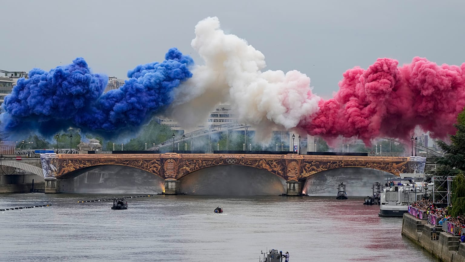 Spettatori francesi in attesa degli atleti sotto la pioggia