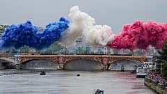 Spettatori francesi in attesa degli atleti sotto la pioggia