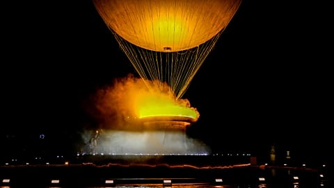 Teddy Riner and Marie-Jose Perec watch as the cauldron rises in a balloon in Paris, France, during the opening ceremony of the 2024 Summer Olympics, Friday, July 26, 2024.