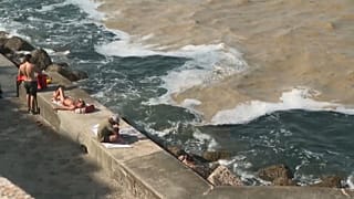 People sitting by the sea at Ancona's Portonovo