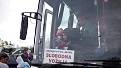 Frau mit Kind steigt in Berkasovo (Serbien) aus einem Bus, der sie an die serbisch-kroatische Grenze gebracht hat, 27. September 2015.