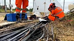 Techniker der SNCG arbeiten an der Erneuerung von Kabeln entlang der Bahnlinie in Courtalain, 26. Juli 2024