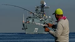 Ein Fischer wickelt seine Angelrute auf, als das Patrouillenboot "Neustraschimy" zu einem "Arbeitsbesuch" in Havanna einläuft, 27. Juli 2024