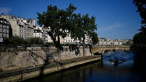 A man walks along the Seine river at the 2024 Summer Olympics, Sunday, July 28, 2024, in Paris, France.
