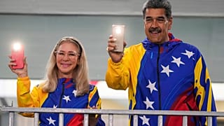 Maduro y la primera dama Cilia Flores encienden las linternas de sus teléfonos móviles tras votar en las elecciones presidenciales en Caracas, Venezuela, en 2024.