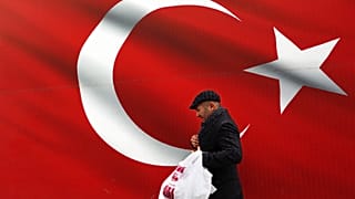 Bir adam, 31 Mart 2019 Pazar günü Ankara'da dev bir Türk bayrağının önünde yürürken görüntüleniyor. (Arşiv)