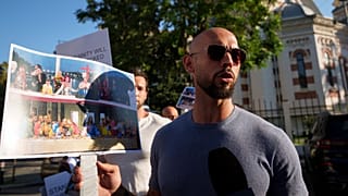 O influenciador das redes sociais Andrew Tate segura uma fotografia de uma cena da cerimónia de abertura dos Jogos Olímpicos de Paris, que se assemelha à obra "A Última Ceia" de Leonardo da Vinci.