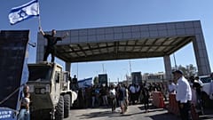 Bir protestocu, Sde Teiman askeri üssünün dışında tutuklulara yönelik kötü muamele nedeniyle sorgulanan askerlere destek olmak için İsrail bayrağını sallarken görüntüleniyor