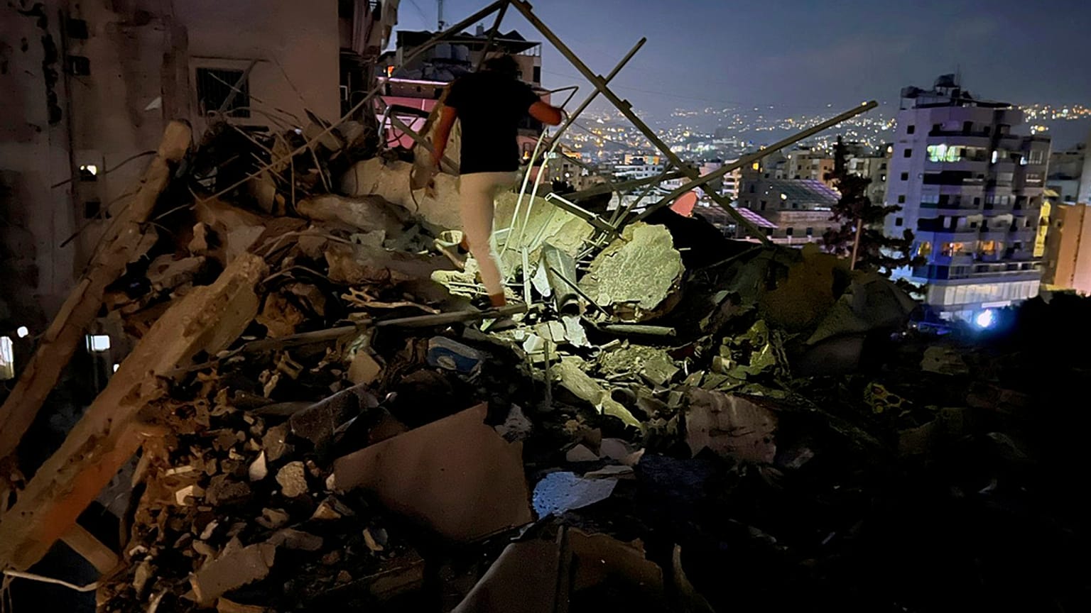 Um homem inspecciona um edifício destruído que foi atingido por um ataque aéreo israelita nos subúrbios do sul de Beirute, Líbano, terça-feira, 30 de julho de 2024 (AP Photo/Hussein Malla)
