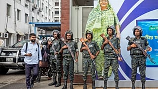 Askeri personel, ulusal yas gününde Başbakan Hasina'nın büyük bir portresinin önünde nöbet tutuyor.